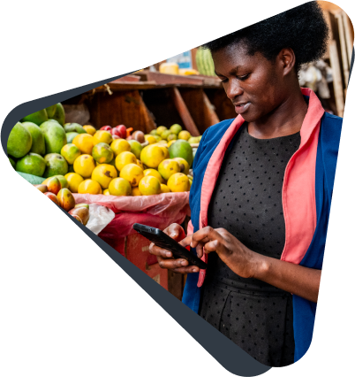 A woman uses mobile money to purchase fruit at a market in Rwanda.